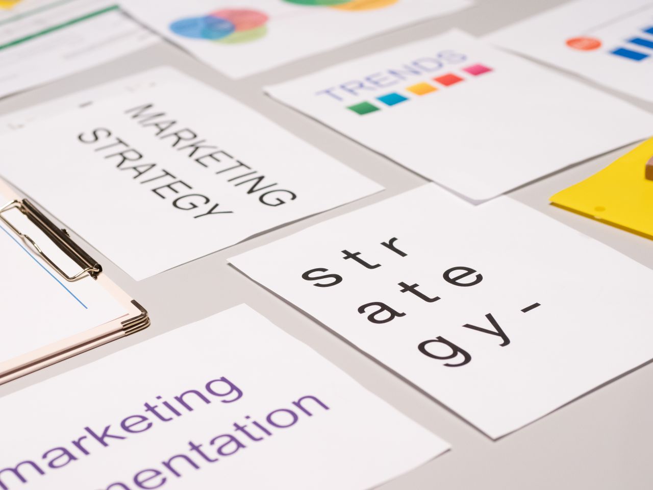 Une vue plongeante sur des documents de stratégie marketing et des graphiques disposés sur un bureau, illustrant la planification commerciale.