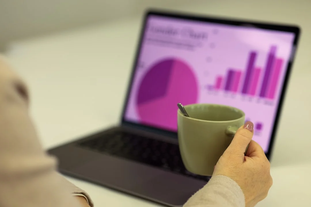 Un espace de travail contemporain où des mains analysent des données marketing sur un ordinateur portable et des documents papier.